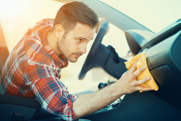 Homem limpando o painel de seu carro
 - Foto, Imagem