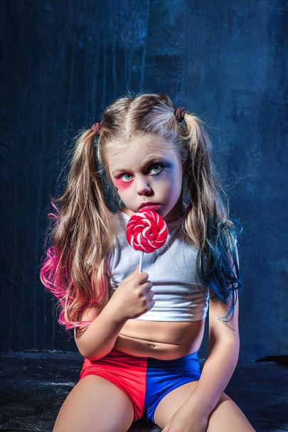 The funny crasy girl with candy on dark background - Фото, изображение