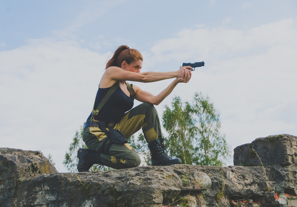 beautiful military girl aiming a pistol - Фото, изображение