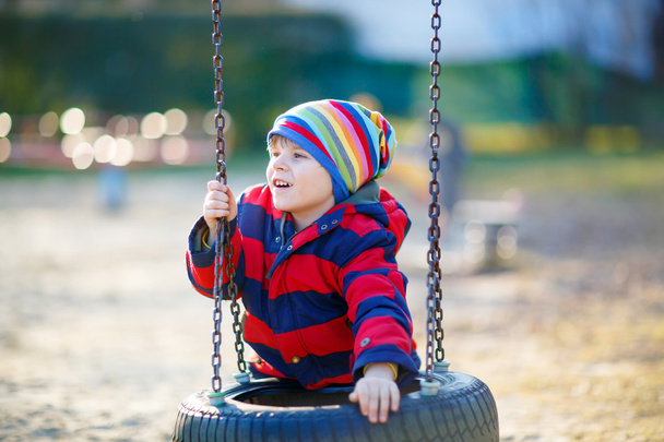 Μικρό παιδί αγόρι έχει τη διασκέδαση στην αλυσίδα swing σε εξωτερικούς χώρους - Φωτογραφία, εικόνα