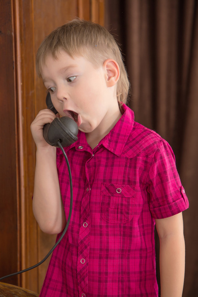 The boy says into the phone old - 写真・画像