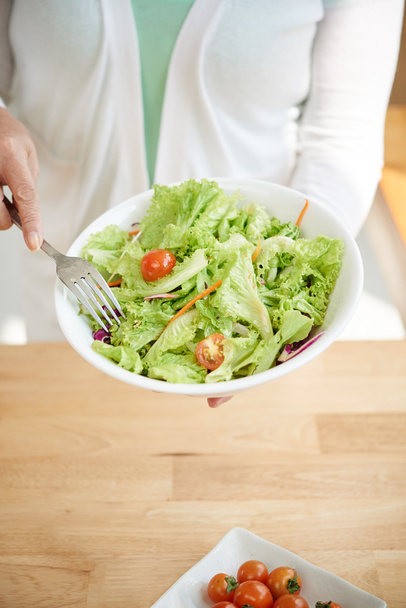 Frau hält große Schüssel Salat in der Hand - Foto, Bild