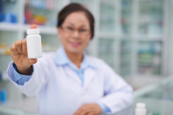 Pharmacien montrant bouteille avec des vitamines
 - Photo, image