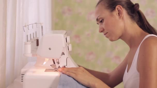 Young woman sews on the sewing machine - Séquence, vidéo