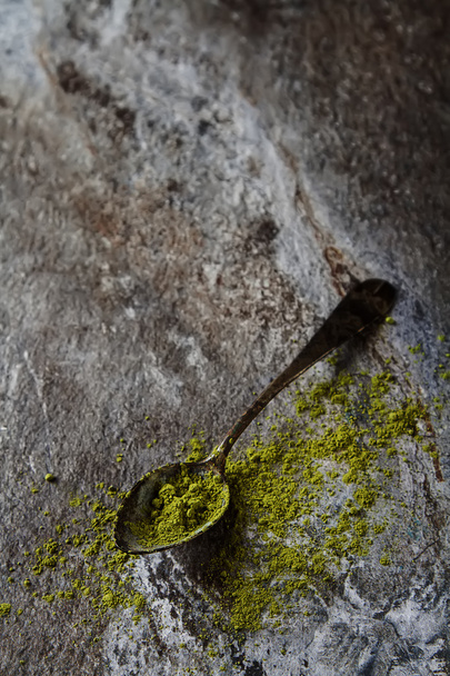 Matcha tea on an old vintage spoon. Gray background. - Fotó, kép