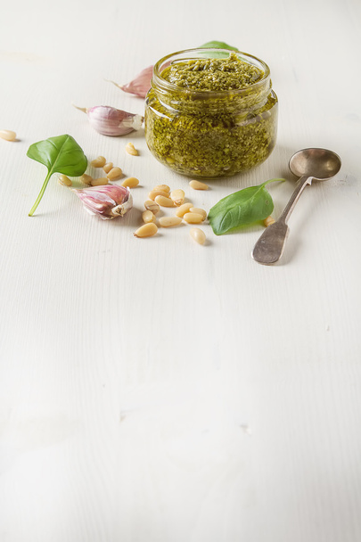 Homemade green pesto sauce with basil and pine nuts in white mor - Photo, image