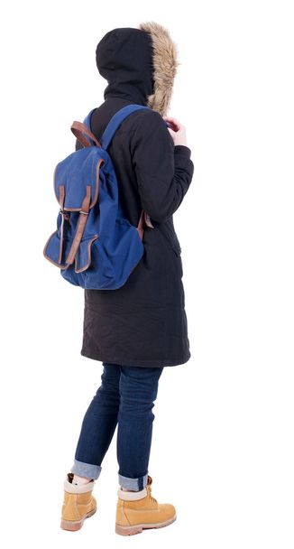 Back view woman in winter jacket  with a backpack looking up - Fotografie, Obrázek