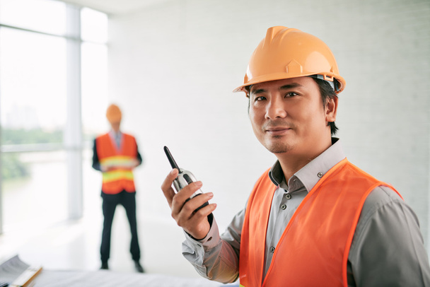 contractor with walkie-talkie in hands - Фото, изображение