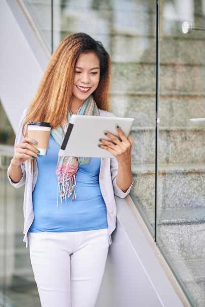γυναίκα πίνοντας καφέ και διαβάζοντας ειδήσεις για tablet - Φωτογραφία, εικόνα