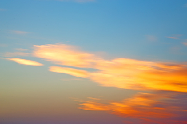 в червоному блакитному небі хмара і схід сонця помаранчевий колір
 - Фото, зображення