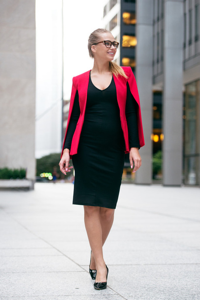 Full-length portrait of a smiling business woman walking away from the office - Fotoğraf, Görsel