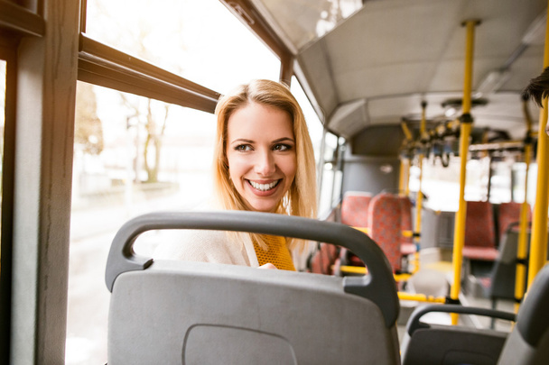 Beautiful young woman traveling by bus, having fun - Zdjęcie, obraz