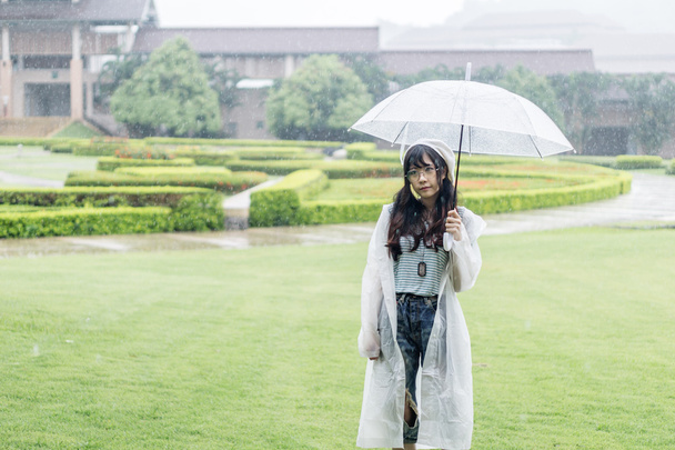 Şemsiye ve yağmurluk ile şirin Asyalı kız  - Fotoğraf, Görsel