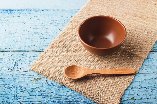 Ceramic bowl and wooden spoon on the table - Valokuva, kuva