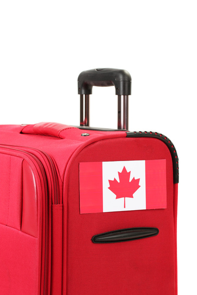 roter Koffer mit Aufkleber mit kanadischer Flagge isoliert auf weißem Grund - Foto, Bild