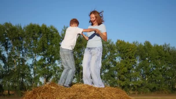 una chica con un niño jugando en un pajar
 - Metraje, vídeo