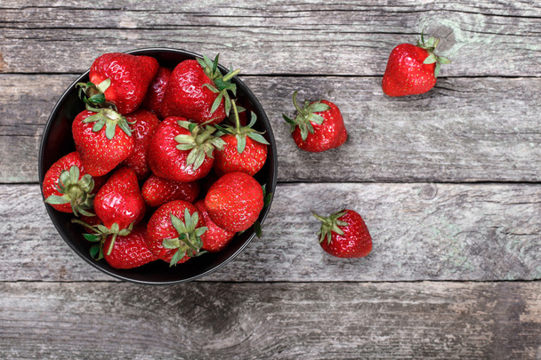 Sweet ripe strawberries in plate on wooden table, selective focus, top view - 写真・画像