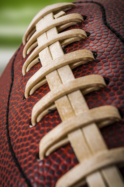 Macro de uma bola de futebol americana desgastada vintage com laços visíveis, pontos e padrão de pele de porco
 - Foto, Imagem