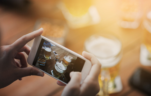 close up of hands with smartphone picturing beer - Fotografie, Obrázek