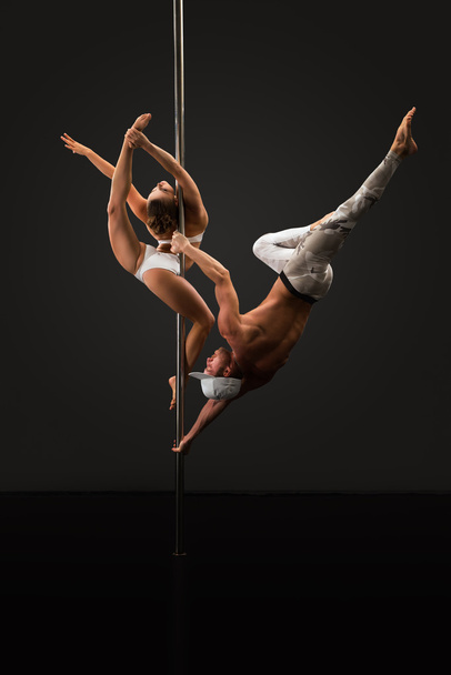 Studio photo of people dancing on pole in pair - Фото, изображение