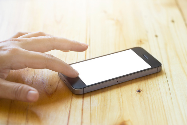 Frau benutzt Smartphone mit leerem Bildschirm auf Tischhintergrund - Foto, Bild