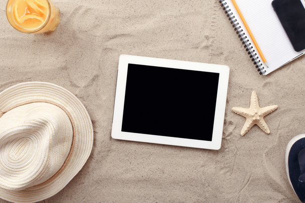 Tablet PC digital con pantalla en blanco y artículos de playa
 - Foto, imagen