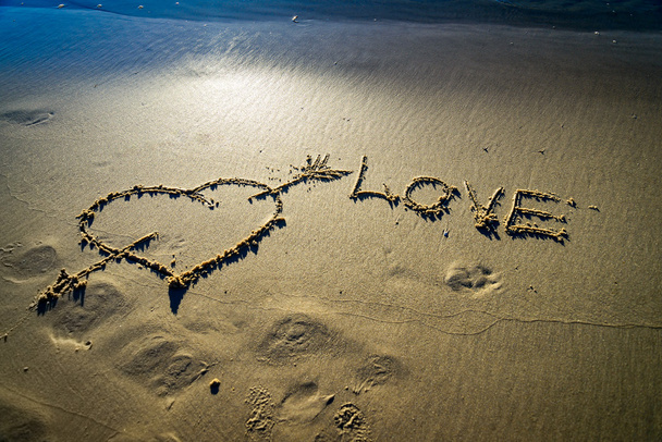 Coeur et flèche dessinés sur sable
 - Photo, image