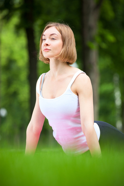 Young woman is stretching in the park. - Photo, Image