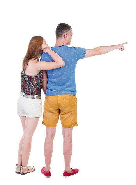 young couple in short pointing at wal - Foto, Bild