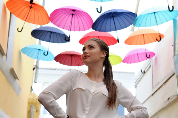 Girl posing under colorful umbrellas - Foto, Imagen