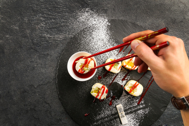 Sweet sushi with red strawberry jam on a black plate - Φωτογραφία, εικόνα