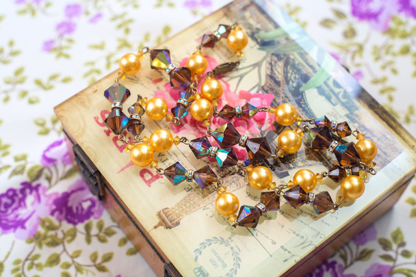Vintage gyöngyök, kristály és gyöngy doboz és textil háttérrel - Fotó, kép