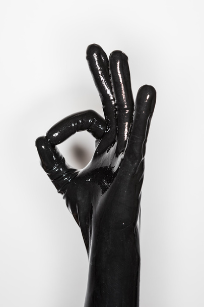 gesture of a hand wearing a black latex glove, signalling excell - 写真・画像