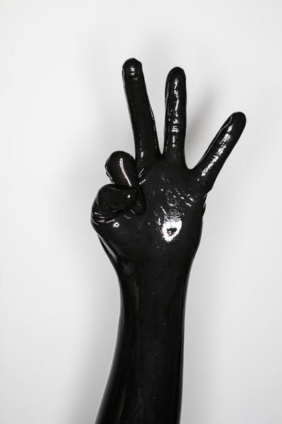 gesto de una mano con un guante de látex negro
  - Foto, Imagen