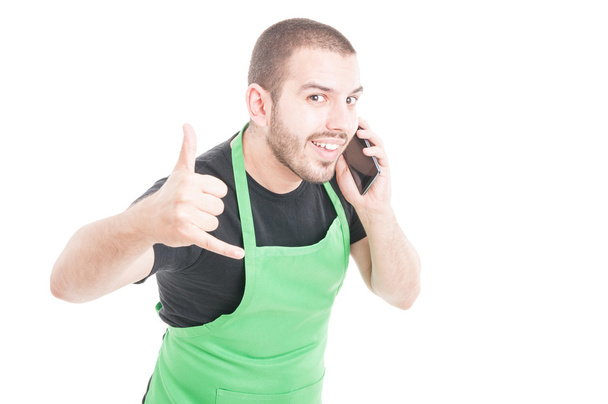 Hypermarket clerk making call me gesture at phone - Photo, Image