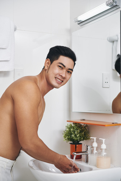 Mężczyzna myje twarz w łazience - Zdjęcie, obraz