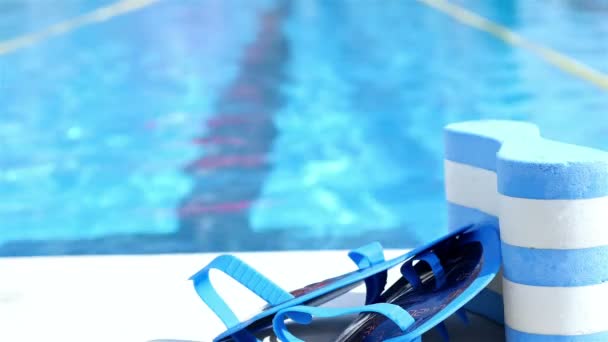 Swimming equipment on the edge of a pool, swimmer in the water - Footage, Video