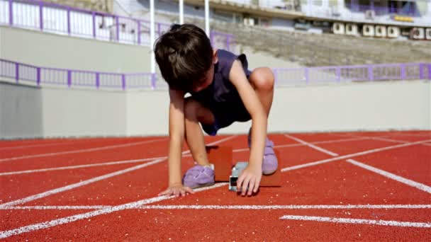 Little boy preparing to run in an athletic track - Footage, Video