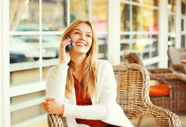 Happy pretty smiling woman talking on smartphone in cafe - Zdjęcie, obraz