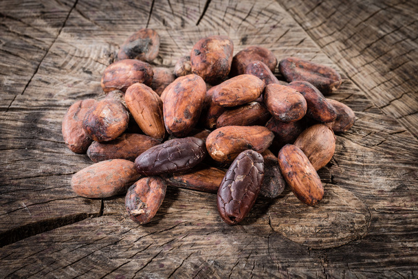 Cocoa beans on wooden background. Organic food - Fotografie, Obrázek