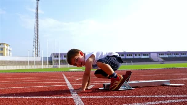 Vídeo divertido de un niño de 2 años preparándose para correr desde un bloque de partida
 - Metraje, vídeo