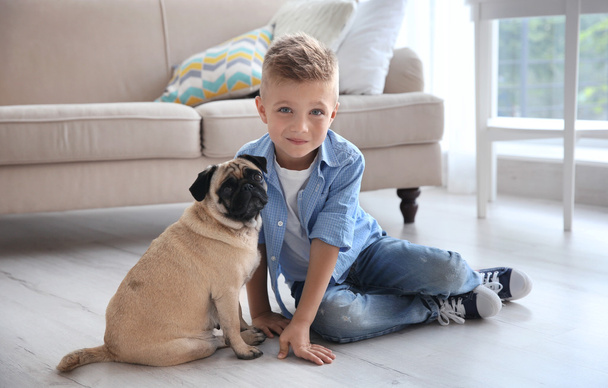 boy with pug dog on floor - Fotó, kép