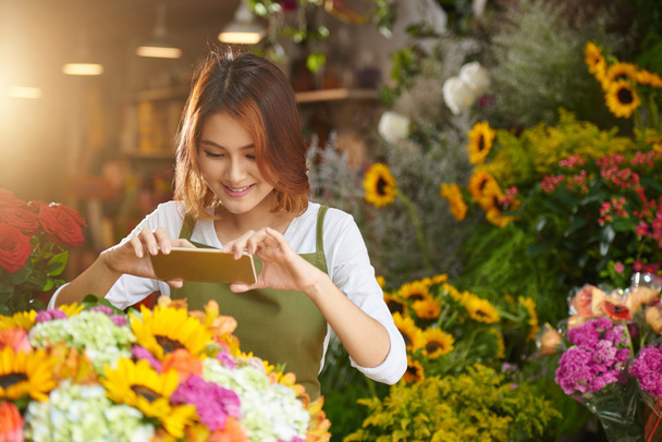 femme utilisant un smartphone pour prendre des photos de fleurs
 - Photo, image