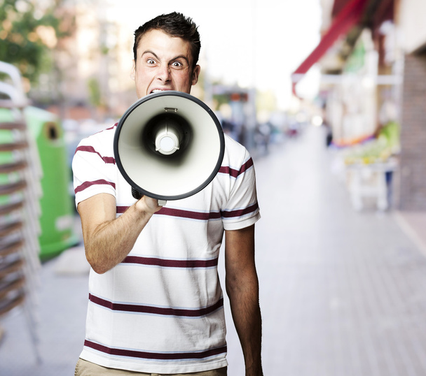 πορτρέτο του νεαρού φωνάζοντας με τον τηλεβόα, στην οδό - Φωτογραφία, εικόνα