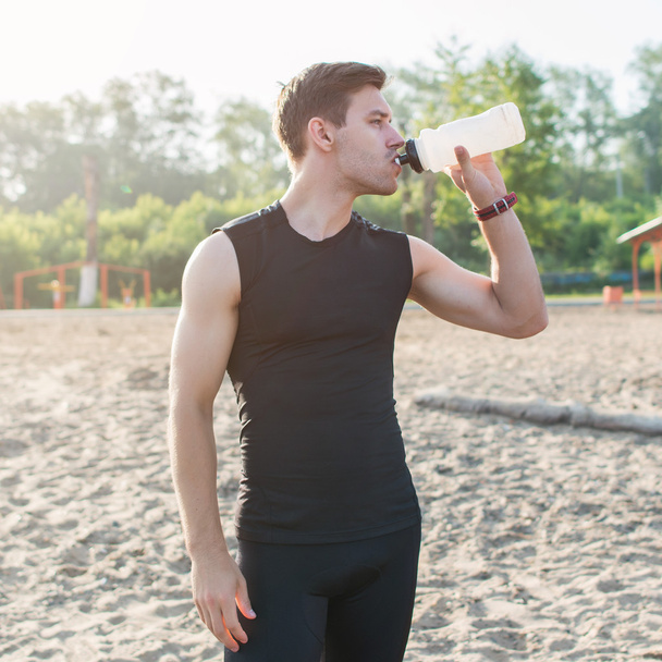Athletic fit man drinking water  - Foto, afbeelding