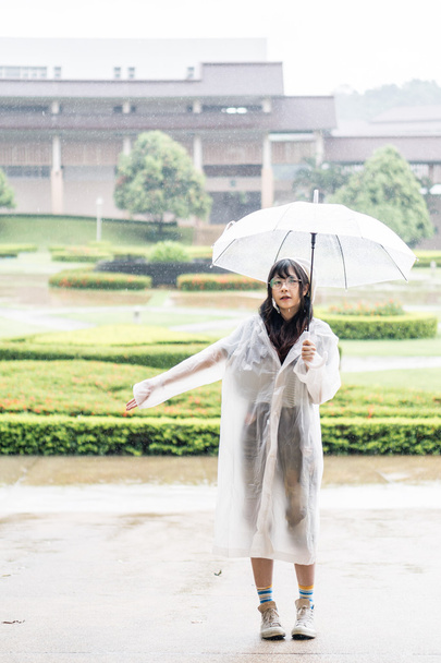 Charming Asian girl  with umbrella and raincoat  - Photo, Image