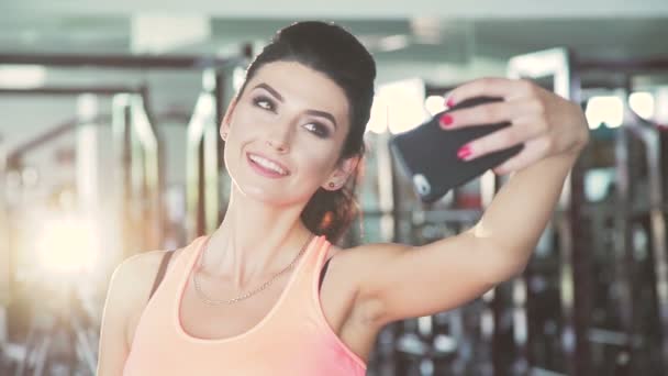 Glamour girl taking selfie in the gym. Slow motion - Filmati, video