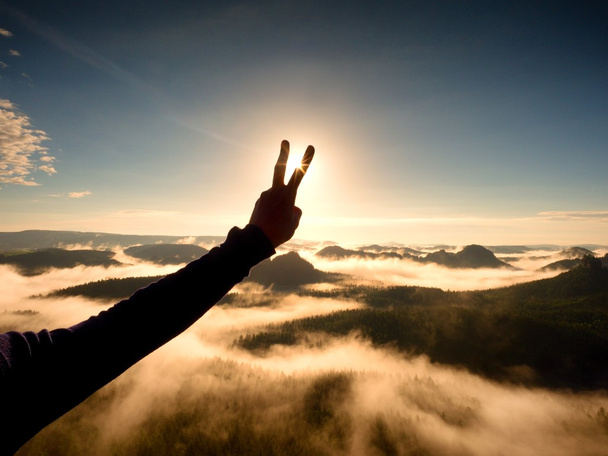 La main de l'homme fait la victoire à Sun. Coucher du jour brumeux dans les montagnes
 - Photo, image