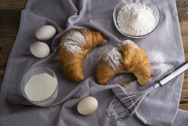 Still life of croissants, eggs, milk and flour. Rustic style. - Фото, зображення