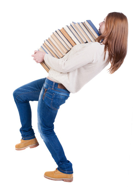 A girl carries a heavy pile of books. back view. Rear view peopl - Zdjęcie, obraz